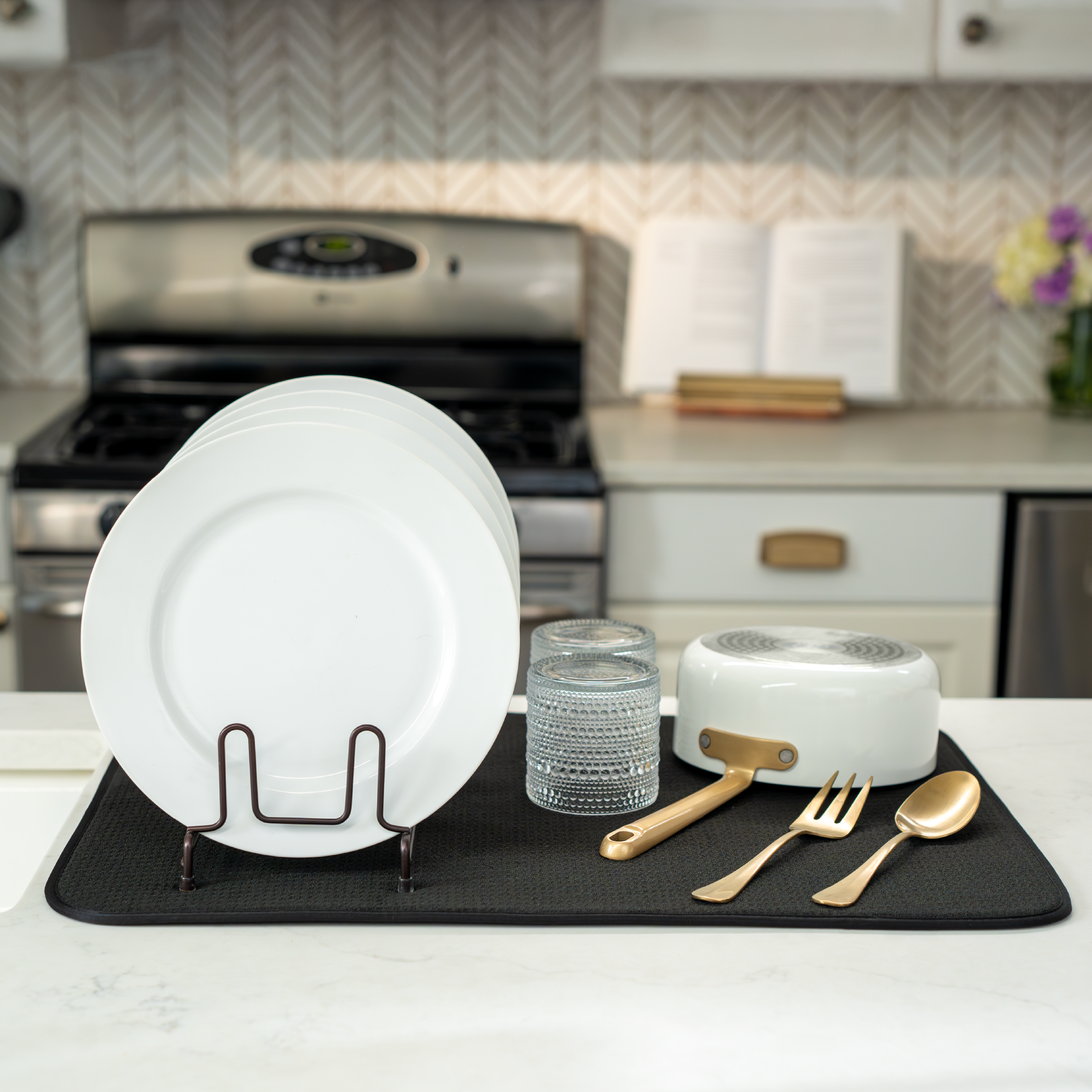various cookware and bakeware on a black microfiber XL dish drying mat in a clean kitchen