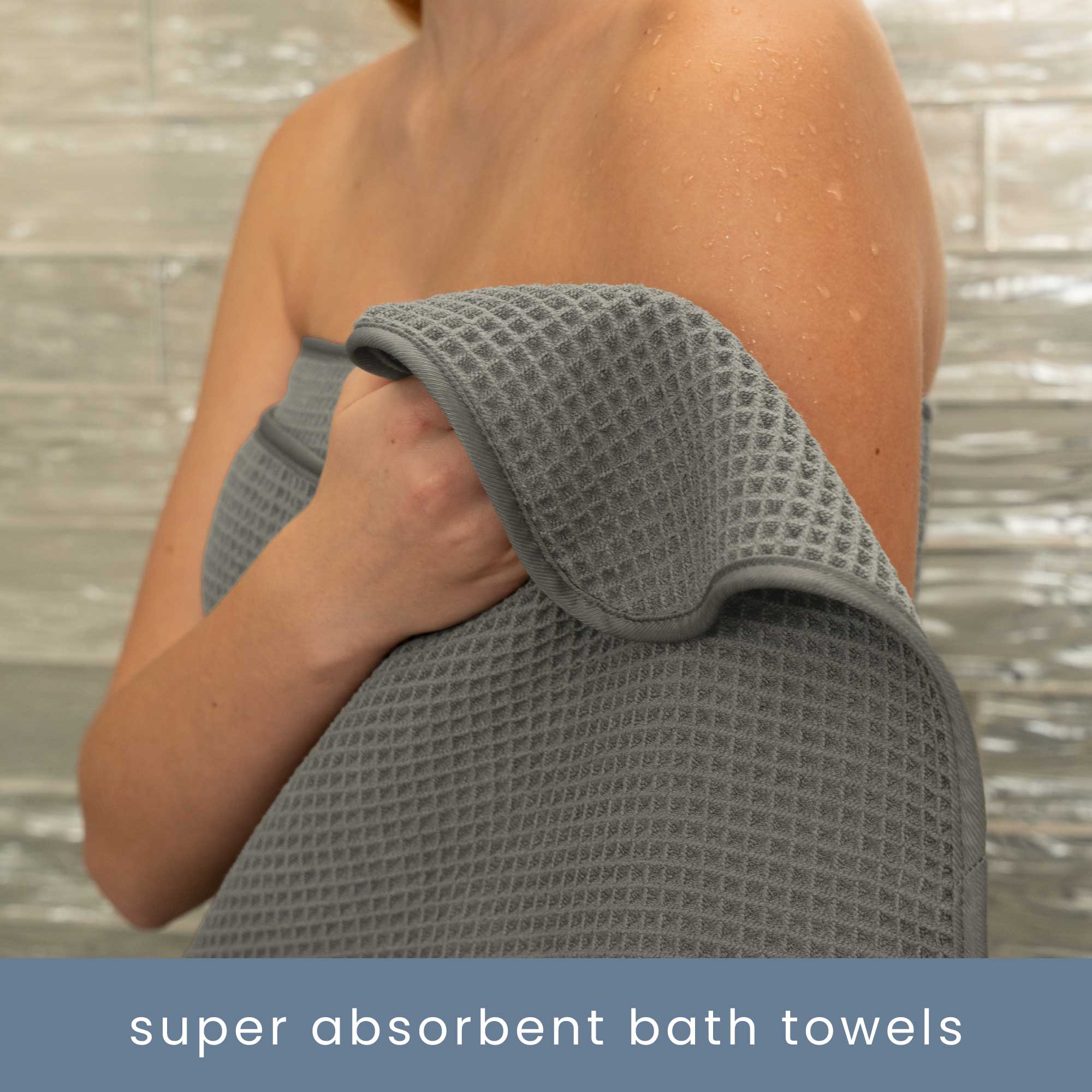 Person holding a grey, super absorbent waffle bath towel drying off their arm after a shower