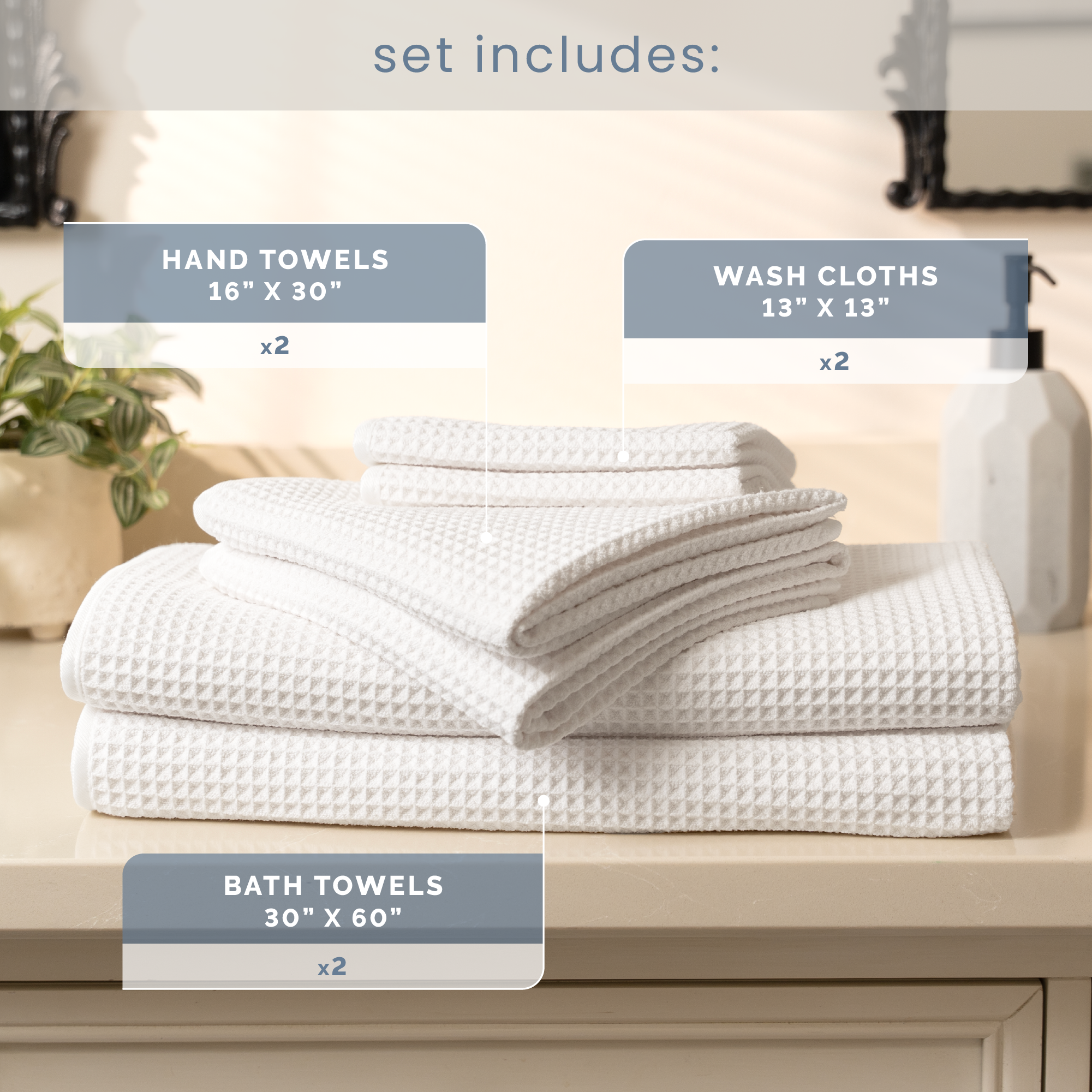 Set of white towels including hand towels, washcloths, and bath towels on a bathroom counter.